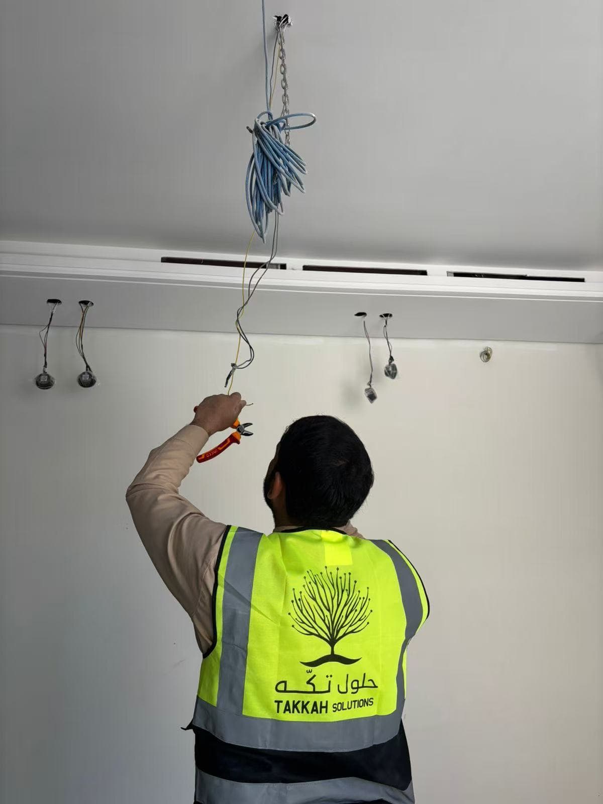 Takkah technician connecting ceiling wiring